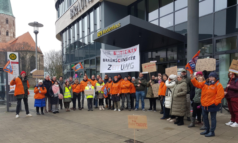 Personengruppe mit Demonstartionsschildern vor dem Gebäude der Braunschweiger Nachrichten – 